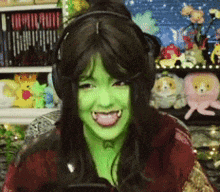 a woman with green paint on her face is wearing headphones