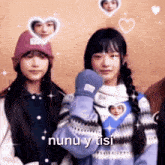 two girls are standing next to each other and one of them is wearing a sweater with a picture of a person on it .