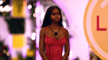 a woman in a red dress is standing in front of a sign that says l