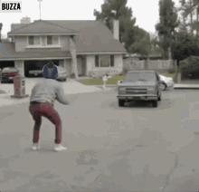 a car is driving down a street with buzza written on the bottom right