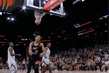 a basketball player wearing a phx jersey lays on the ground