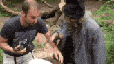 a man holding a canon camera talks to a man in a wizard costume