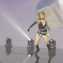 a woman is dancing on a stage with a reflection of her in the floor