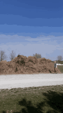 a large pile of hay is on the side of a road