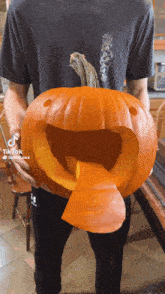 a man is holding a pumpkin that has been carved to look like a face