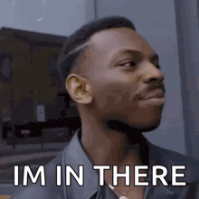 a man is standing in front of a building and making a funny face .