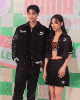 a man and a woman standing in front of a sign that says puma on it