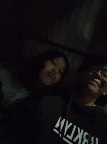 a boy and a girl are posing for a picture and the girl is wearing a black hoodie that says tbktam