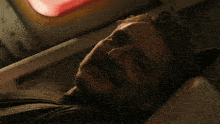 a man with a beard is laying in a dark room with a red light behind him