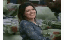 a woman is sitting on a couch smiling .