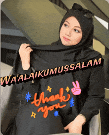 a woman wearing a black hijab with a thank you sticker on it