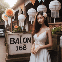 a woman in a white dress stands in front of a sign for balon 168