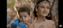 a woman is holding a baby in her arms and looking at it