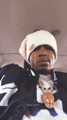 a man wearing a beanie and a sweater says friday at the top of the photo
