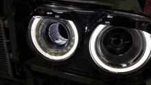 a close up of a car headlight with a white ring