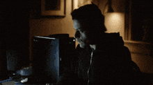 a man sitting at a desk with a lamp on