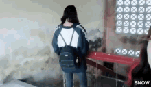 a girl with a backpack is standing in front of a red railing .
