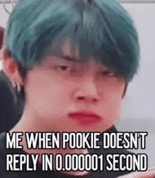 a young man with green hair is making a funny face while looking at the camera .