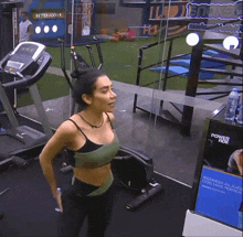 a woman stands in a gym with a sign that says power ride