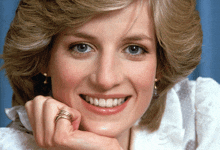a close up of a woman 's face with her hand on her chin