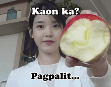 a woman is holding a half apple with the words kaon ka pagpalit written above her