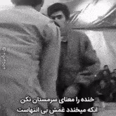 a black and white photo of two men fighting each other in a room .