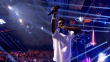 a man singing into a microphone in front of a crowd with a sign that says ' x ' on it