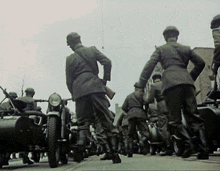 a group of soldiers are standing on a street with motorcycles