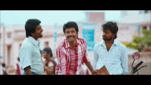 three men are standing next to each other on a street and talking