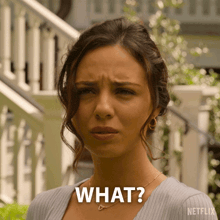 a woman is making a funny face with the words what on her face