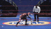 two wrestlers are wrestling in a ring with a logo on the floor that says cmpl .