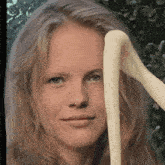 a close up of a woman 's face with a snake coming out of her hair