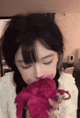 a girl with a tattoo on her face holds a pink flower