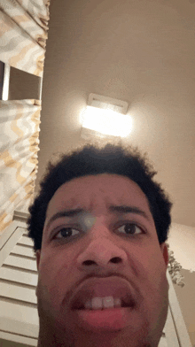 a man making a funny face in front of a shower curtain