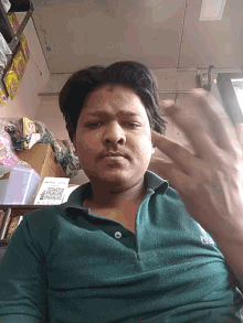 a man wearing a green polo shirt has a qr code on his chest