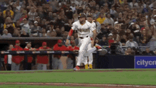 a baseball player wearing a padres uniform runs towards home plate