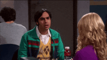 a man in a green jacket talking to a woman