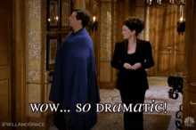a man in a blue cape is standing next to a woman in a black suit and says wow so dramatic