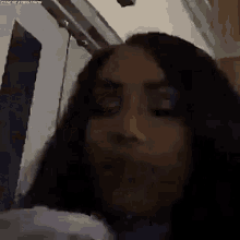 a close up of a woman 's face in a dark room with a door in the background .