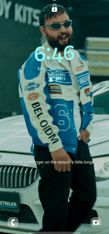 a man standing next to a car with the time of 6:46 on the screen