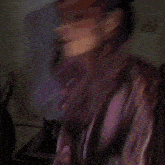 a blurry picture of a woman with long hair in a purple jacket