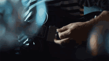 a close up of a person playing a guitar that says ' fender ' on the neck