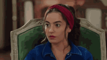 a woman with a red headband is sitting in a chair