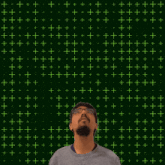 a man stands in front of a green background with the number 21 in yellow