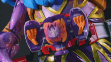 a close up of a toy with a purple and red belt that looks like a robot