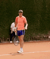 a man holding a tennis racquet on a court