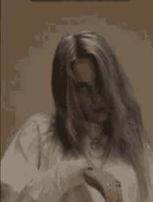 a woman with long gray hair is wearing a white shirt