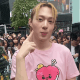 a man wearing a pink shirt with an apple on it