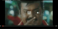 a man with a mustache is covering his mouth with his hand .