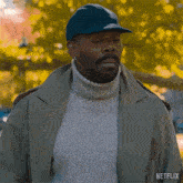 a man wearing a trench coat and a hat says oh okay